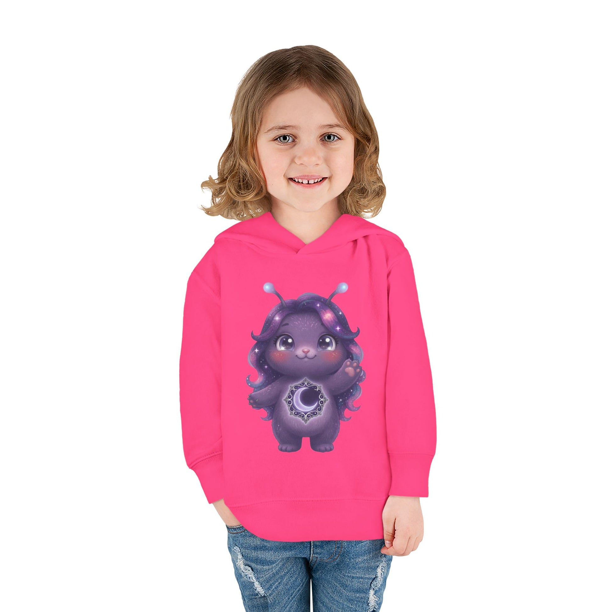 Pink hoodie featuring a cute purple galaxy creature with antennae, long wavy hair, and a glowing crescent moon emblem on its chest.