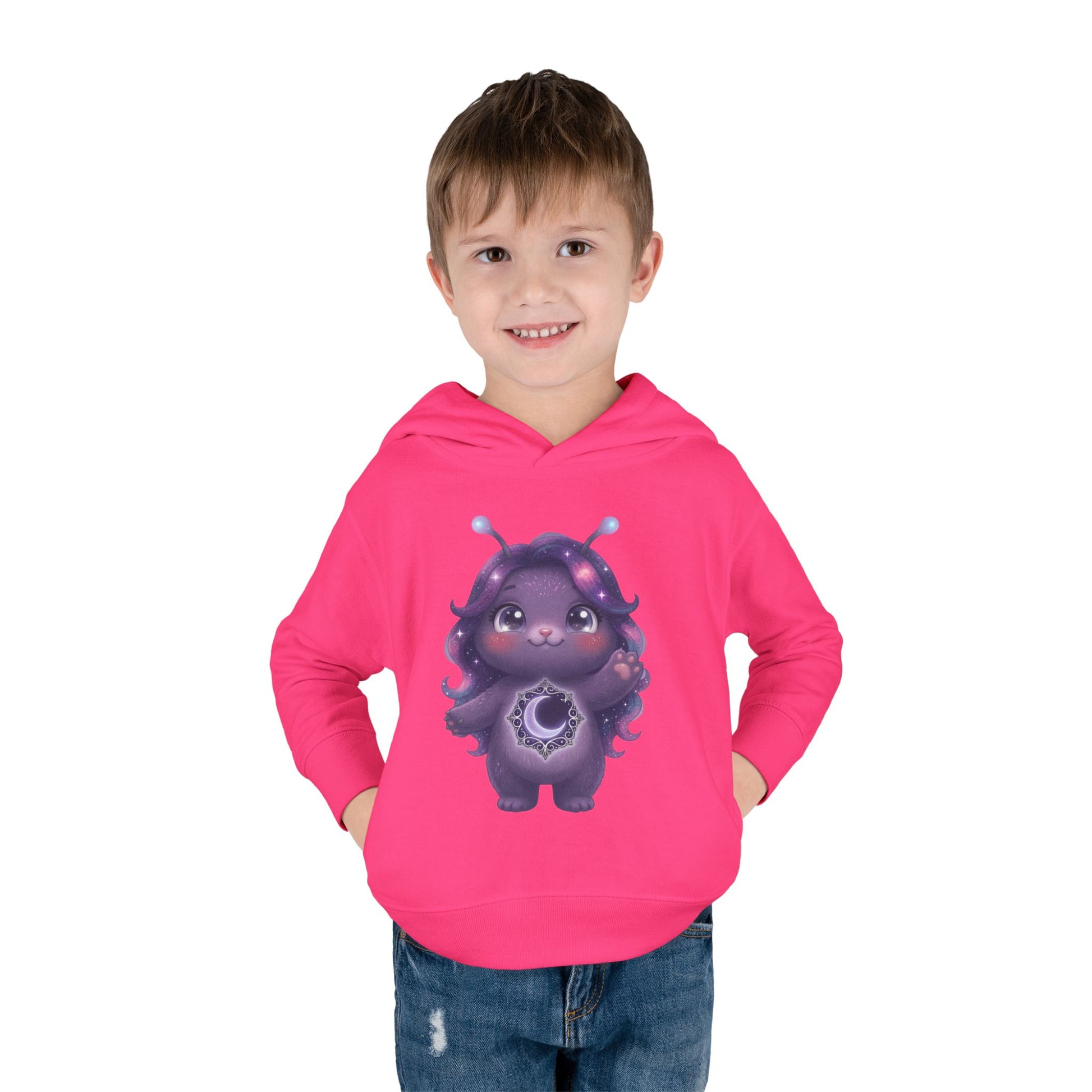 Pink hoodie featuring a cute purple galaxy creature with antennae, long wavy hair, and a glowing crescent moon emblem on its chest.